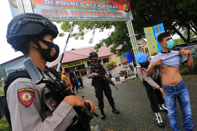 Personel Kepolisian Polres Aceh Barat melakukan pemeriksaan terhadap pengujung di gerbang pintu masuk Mapolres Aceh Barat, Aceh, Kamis (1/4/2021). Polres Aceh Barat memperketat dan meningkatkan pengamanan sebagai bentuk antisipasi pascainsiden serangan yang diduga teroris di Mabes Polri Jakarta.