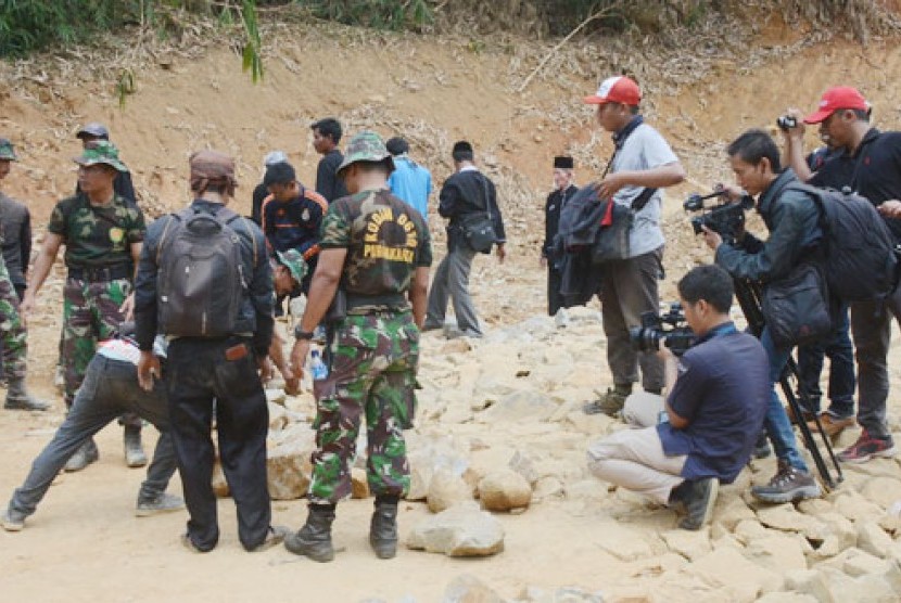 Personel Kodim 0619/Purwakarta bersama warga bahu-membahu mengangkat material pembangunan jalan.