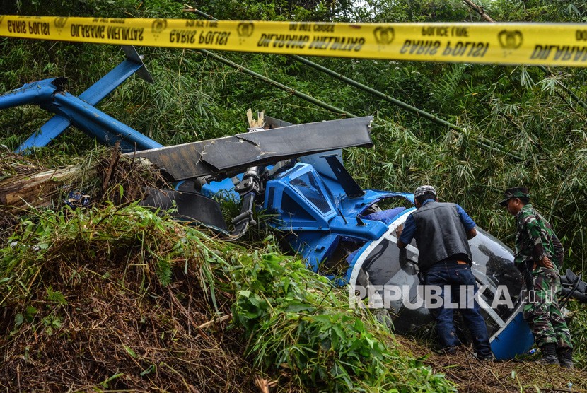 Personel Komisi Nasional Keselamatan Transportasi (KNKT) dan TNI AU Lanud Wiriadinata mengidentifikasi kondisi bangkai pesawat Helikopter B-105 PK EAH PT Air Transport Service pascajatuh di Gunung Situhiang, Cigalantong, Kabupaten Tasikmalaya, Jawa Barat, Ahad (17/3/2019).