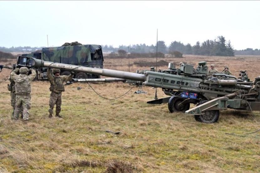 Personel militer mempersiapkan meriam artileri M777A2 howitzer dalam sebuah latihan militer yang dipimpin Amerika Serikat di Oksbol, Denmark, pada 30 Maret 2023.