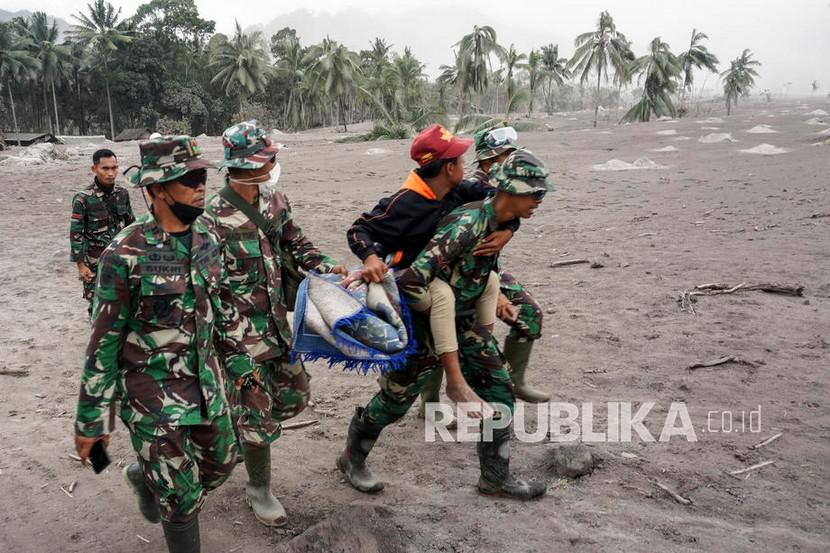  Personel militer mengevakuasi seorang penduduk desa dari daerah yang terkena dampak letusan Gunung Semeru di desa Sumber Wuluh di Lumajang, Jawa Timur, Senin (6/12.). Gunung berapi meletus pada 04 Desember, menewaskan sedikitnya 14 orang dan menyebabkan puluhan lainnya terluka. 