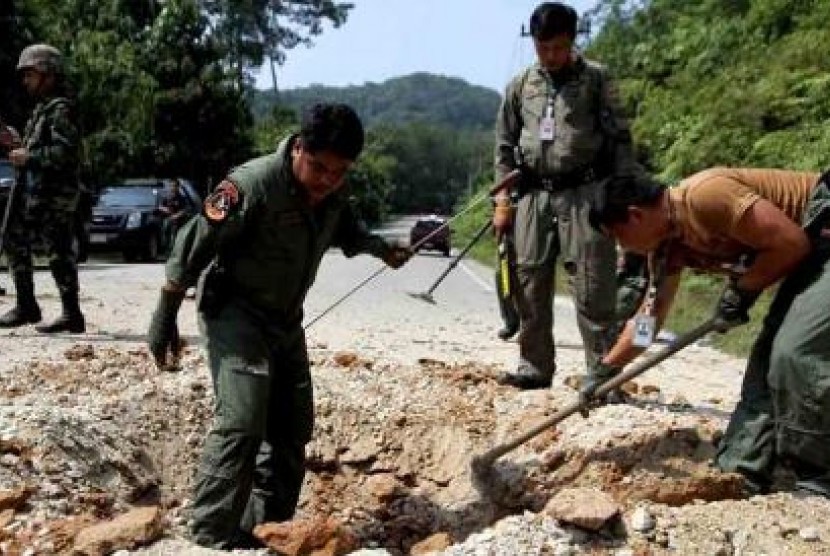 Personel militer Thailand memeriksa jalan lokasi ledakan di Narathiwat.