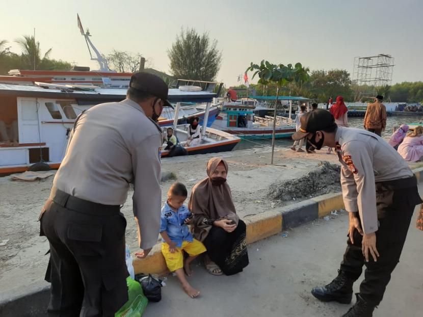 Personel Polda Banten saat melakukan sosialisasi protokol kesehatan di Kawasan Pantai Gopek, Karangantu, Kota Serang. 