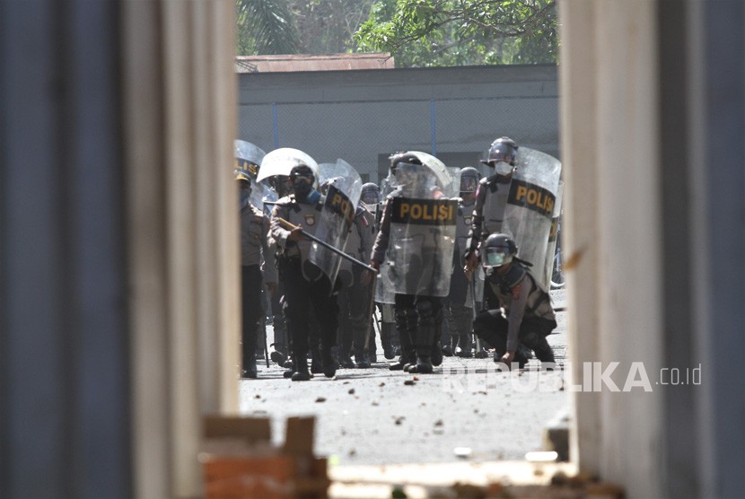 Personel Polda Sulawesi Tenggara berusaha membubarkan mahasiswa yang berusaha masuk ke dalam gedung DPRD Sulawesi Tenggara saat aksi unjuk rasa di Kendari, Sulawesi Tenggara, Kamis (26/9/2019).