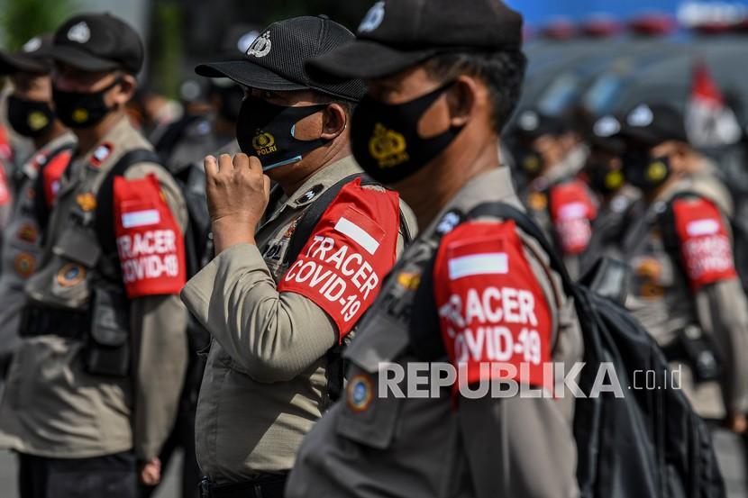 Personel polisi merapikan maskernya saat mengikuti Apel Kesiapan Bhayangkara Pembina Keamanan dan Ketertiban Masyarakat (Bhabinkamtibmas) dan Tenaga Kesehatan Polri di Lapangan Promoter, Polda Metro Jaya, Jakarta, Kamis (11/2/2021). Polri menyiapkan 40.366 personel Bhabinkamtimbas dan tenaga kesehatan yang bertindak sebagai pendeteksi dini dalam mengantisipasi penyebaran COVID-19.