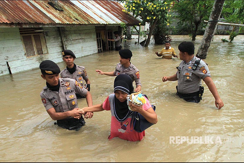 Personel Polisi Unit Reaksi Cepat (URC) Polres Lhokseumawe membantu mengevakuasi warga yang terkepung banjir, di Kecamatan Samudera Geudong, Aceh Utara, Aceh, Sabtu (17/11)