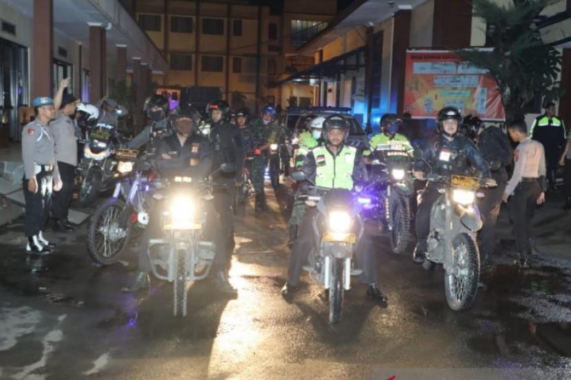 Personel Polresta Bogor Kota dan Kodim 06/06 Kota Bogor melakukan patroli sosialisasi pencegahan penyebaran virus corona di Kota Bogor, Selasa (23/3) malam.