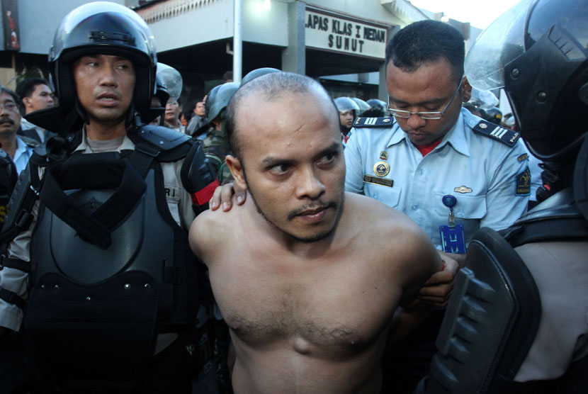  Personel Polri dan TNI membawa seorang napi ketika proses pemindahan para narapidana di Lapas Klas I Tanjung Gusta, Medan, Sumut, Rabu (31/7).     (Antara/Irsan Mulyadi)