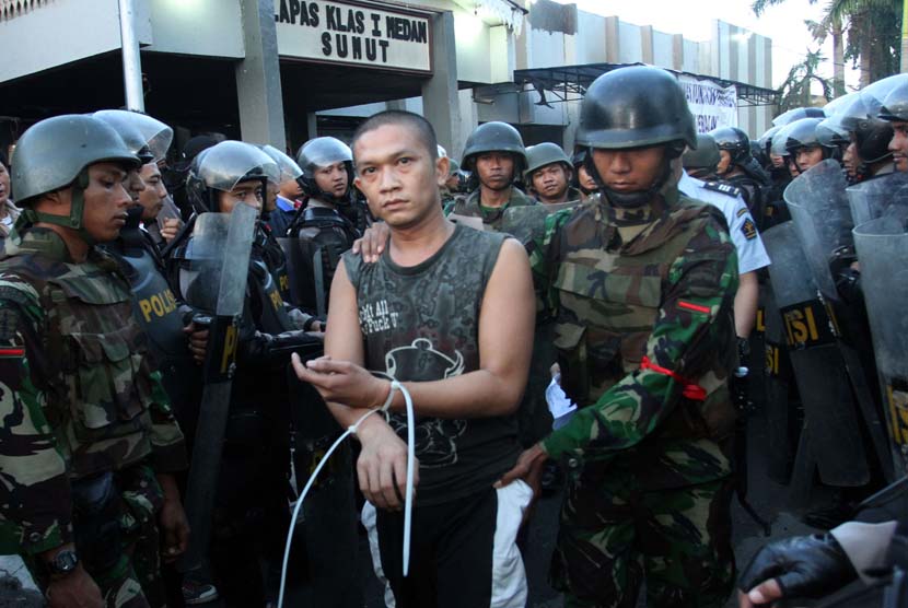 Personel Polri dan TNI membawa seorang napi ketika proses pemindahan para narapidana di Lapas Klas I Tanjung Gusta, Medan, Sumut, Rabu (31/7).     (Antara/Irsan Mulyadi)