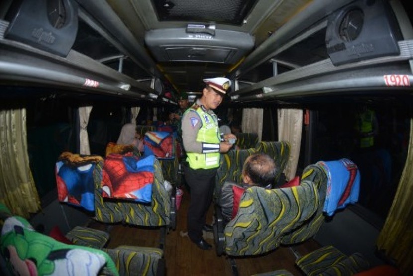 Personel Polri melakukan pemeriksaan identitas penumpang bus di jalan raya Pantura Situbondo, Jawa Timur, Sabtu (18/5/2019) malam. Pemeriksaan kendaraan beserta penumpang dan barangnya tersebut untuk mengantisipasi pergerakan massa yang akan berangkat ke Jakarta menjelang pengumuman hasil rekapitulasi suara Pemilu 2019 di kantor KPU. 