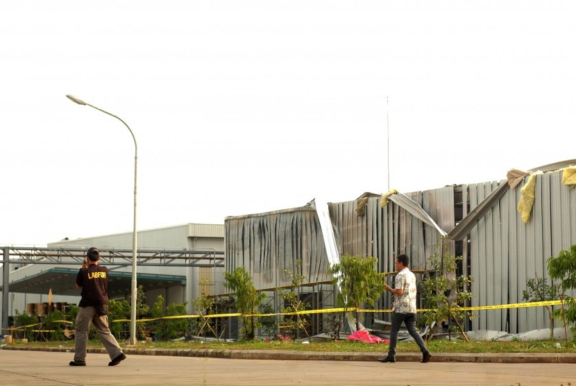 Personel Puslabfor Mabes Polri berjalan di area tempat kejadian perkara kebakaran akibat ledakan di pabrik kosmetik, PT Mandom, di Cibitung, Bekasi, Jawa Barat, Jumat (10/7).