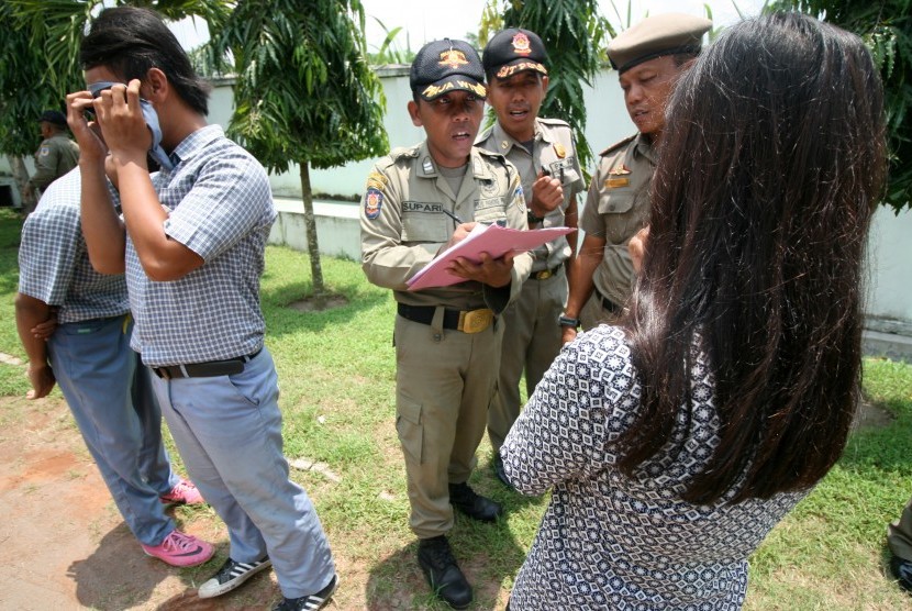 Personel Satpol PP melakukan pendataan kepada sejumlah pelajar bolos sekolah di halaman kantor Dinas Pendidikan, Kabupaten Kediri, Jawa Timur, Kamis (25/2). 