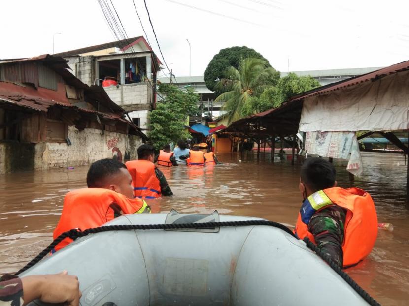 Personel TNI AU membawa perahu karet mengevakuasi warga RW 03 dan RW 04, Kelurahan Cipinang Melayu, Kecamatan Makasar, Jakarta Timur yang terendam banjir pada Jumat (20/2).  
