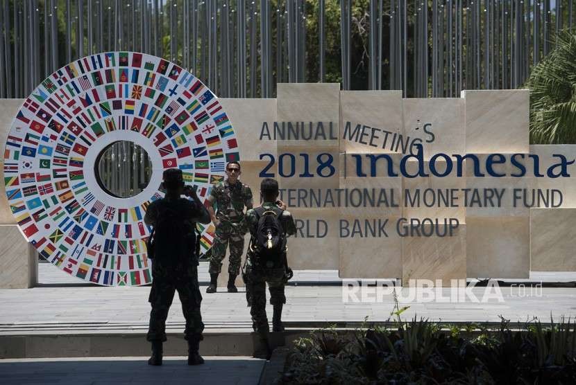 Personel TNI berfoto dengan latar belakang logo bendera berbagai negara di sekitar kawasan yang akan menjadi tempat berlangsungnya pertemuan tahunan IMF-Bank Dunia di Bali Nusa Dua Convention Center (BNDCC), Nusa Dua, Bali, Senin (1/10). 