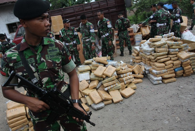 Personel TNI berjaga di samping barang bukti ganja kering yang diamankan, di Medan, Sumatera Utara, Jumat (10/7).  (Antara/Irsan Mulyadi)