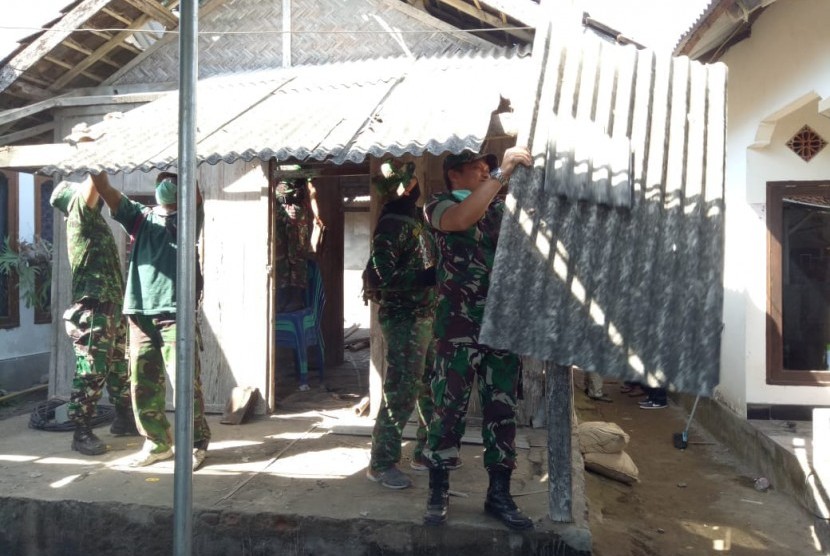 Personel TNI bersama masyarakat membongkar rumah Lalu Muhammad Zohri untuk direnovasi pada Sabtu (14/7).