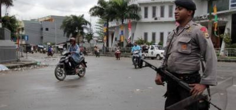 Personil Brimob Polda Maluku siaga mengamankan ruas jalan Dokter Sutomo yang terletak di pusat Kota Ambon, Senin (12/9). Ruas jalan tersebut mulai dinormalisasi menyusul kericuhan antar warga, Ahad  (11/9). 