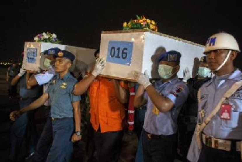 Personil militer mengangkut peti jenazah korban Air Asia QZ 8501 yang tiba di Surabaya untuk diidentifikasi, Jumat (2/1).