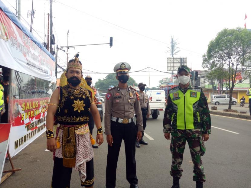 Personil Polres Bogor mengenakan kostum Gatot Kaca, hingga Pitung saat melakukan pemeriksaan di check point Simpang Nagrak, Kecamatan Gunung Putri, Kabupaten Bogor.