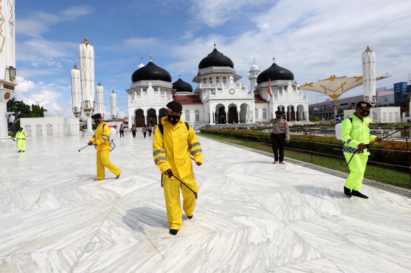 Personil Sabhara Polresta Banda Aceh melakukan penyemprotan disinfektan di masjid raya Baiturrahman, Banda Aceh, Aceh, Rabu (12/5/2021). Penyemprotan cairan disinfektan dilaksanakan untuk mengantisipasi penyebaran dan mencegah penularan COVID-19 yang kembali meningkat di Provinsi Aceh. 