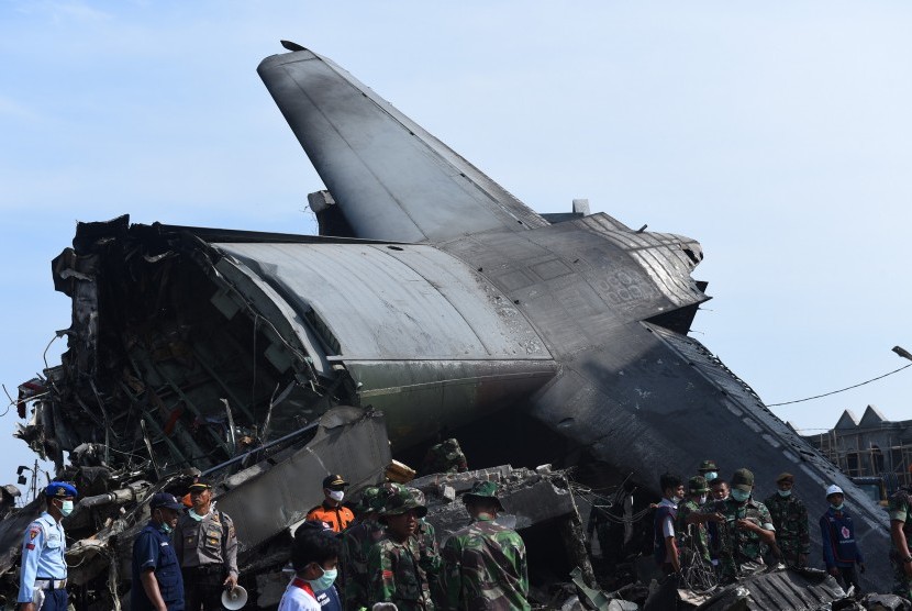 Personil TNI bersama Petugas PMI dan Basarnas melakukan evakuasi puing-puing pesawat Hercules C-130 yang jatuh di Jalan Jamin Ginting, Medan, Sumatera Utara, Rabu (1/7).