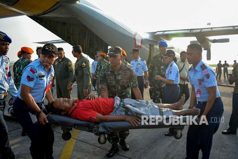 Personel TNI menandu korban luka bencana gempa dan tsunami Palu.