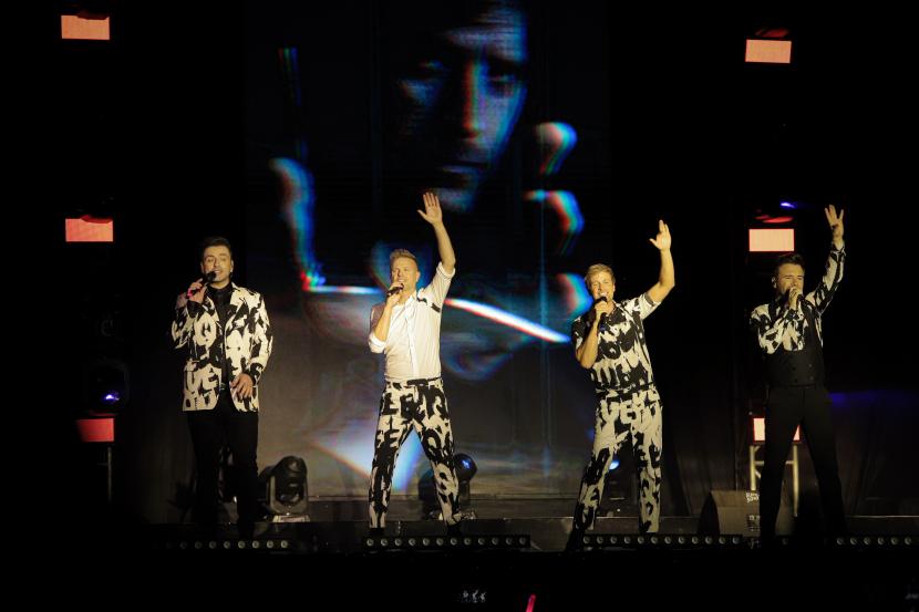 Personil Westlife membawakan lagu saat tampil pada konser 