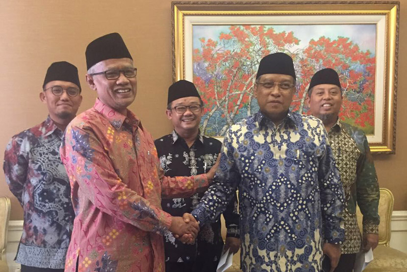 Pertemuan Istana: Ketua Umum PBNU KH Aqiel Siradj bersalaman dengan Ketua Umum PP Muhammadiyah Haedhar Nashir di Istana Negara Jakarta, (1/10).