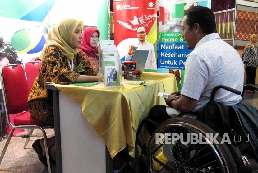 Pertugas BPJS Ketenagakerjaan berbincang dengan seorang penyandang disabilitas pada acara Gebyar Pemberian Manfaat Kepada Penyandang Disabilitas Se Provinsi Jawa Barat oleh BPJS Ketenagakerjaan, di Aula Pusdai, Kota Bandung, Selasa (8/8). 