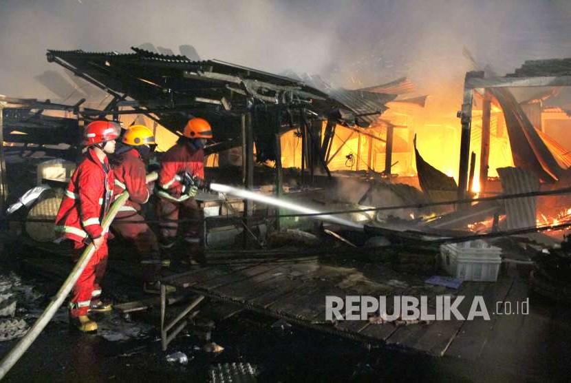 Pertugas pemadam kebakaran berusaha memadamkan api yang menghanguskan Pasar Gedebage, Kota Bandung, Senin (3/9).