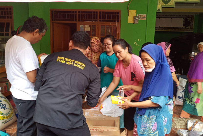 Perwakilan BEM STMIK Nusa Mandiri memberikan bantuan logistik kepada warga yang terdampak banjir di Jalan RA  Kartini, Bekasi. Rabu (1/1).