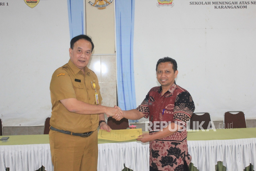 Perwakilan dosen pembimbing UNY, Dr. Eko Budiyanto (kanan) menyerahkan  berkas  mahasiswa Praktek Kependidikan kepada Kepala Sekolah SMAN 1 Karang Anom Masjhor Thahjanto (kiri) di Auditorium sekolah setempat, Senin (21/7/2025). 