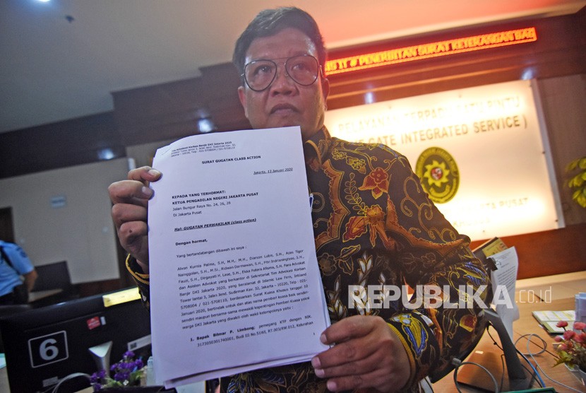 Perwakilan Tim Advokasi Korban Banjir DKI Jakarta 2020 Diarson Lubis menunjukkan surat gugatan class action terkait banjir Jakarta saat mendaftarkan perkara di Pengadilan Negeri Jakarta Pusat, Senin (13/1/2020).