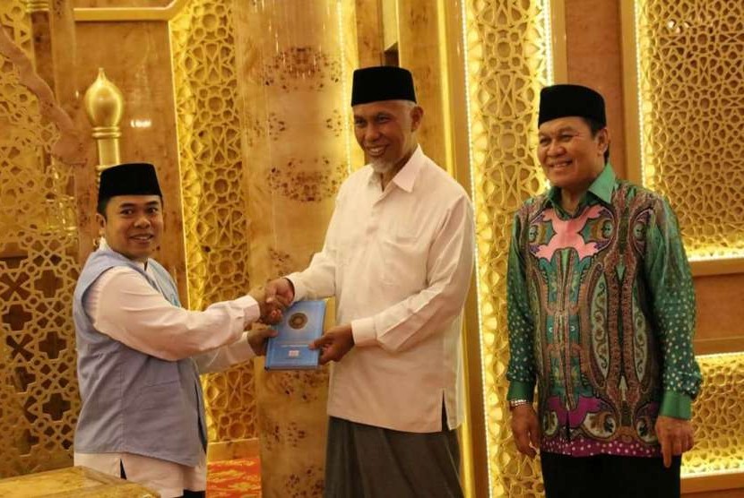 Perwakilan Yayasan Almanarah untuk Wilayah Sumbar  H Mulyadi Muslim Lc, MA (kiri)  menyerahkan wakaf Alquran secara simbolis kepada Wali Kota Padang, Mahyeldi Ansharullah.