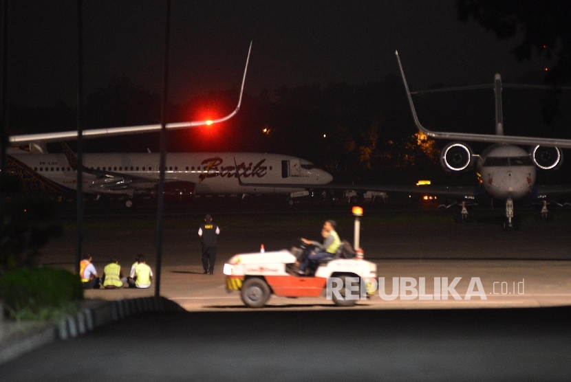  Pesawat Batik Air dengan nomor registrasi PK-LBS (belakang) dipindahkan oleh petugas di Bandara Halim Perdanakusuma, Jakarta, Senin (4/4) malam.  (Republika/Raisan Al Farisi)