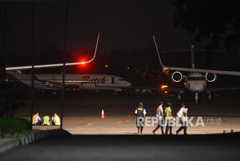 Pesawat Batik Air dengan nomor registrasi PK-LBS (belakang) dipindahkan oleh petugas di Bandara Halim Perdanakusuma, Jakarta, Senin (4/4) malam.  (Republika/Raisan Al Farisi)