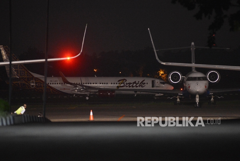 Pesawat Batik Air dengan nomor registrasi PK-LBS (belakang) dipindahkan oleh petugas di Bandara Halim Perdanakusuma, Jakarta, Senin (4/4) malam. 