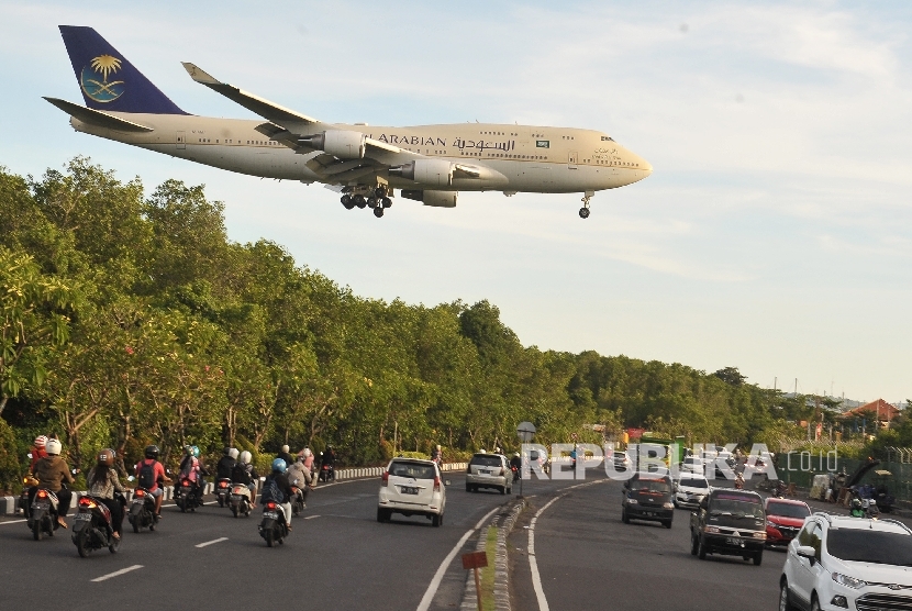 Pesawat Boeing 744 yang membawa Raja Arab Saudi Salman bin Abdulaziz Al Saud melintas di atas jalan sebelum mendarat di Bandara Internasional Ngurah Rai, Denpasar
