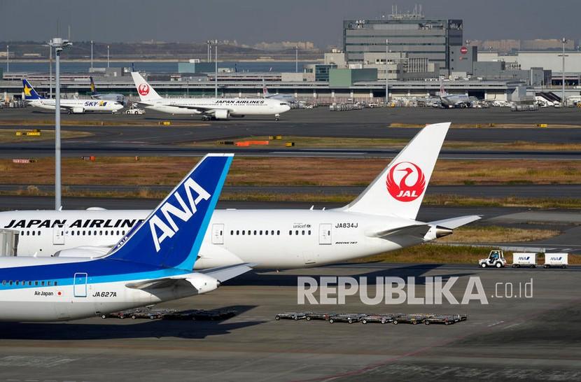  Pesawat diparkir di landasan di Bandara Internasional Haneda di Tokyo, Jepang.  Pemerintah Jepang sedang mempertimbangkan untuk mengakhiri persyaratan tes Covid-19. Dikutip dari Reuters, Senin (23/8/2022), pertimbangan tersebut akan dilakukan khususnya bagi turis yang sudah divaksinasi saat datang ke Jepang. 