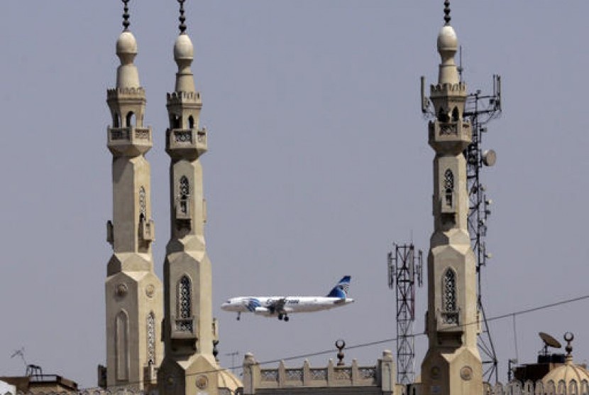 Pesawat Egypt Air terbang melewati menara masjid saat mendekati Bandara Internasional Kairo di Kairo, Mesir. Pemerintah Mesir menyatakan akan membuka kembali seluruh bandara yang melayani penerbangan internasional mulai 1 Juli. ini merupakan pembukaan setelah menangguhkan penerbangan komersial umum sejak Maret lalu untuk mencegah penyebaran wabah Covid-19.