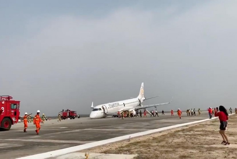 Pesawat Myanmar National Airlines penerbangan UB103 mendarat dengan selamat meski tanpa roda depan di Mandalay International Airport di Tada-U, Myanmar, Ahad (12/5).