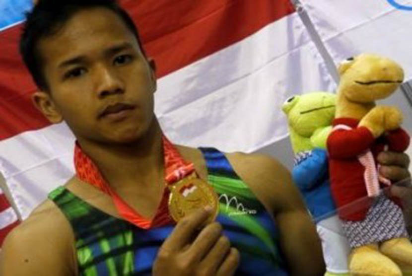 Pesenam Indonesia, Muhammad Try Saputra menunjukkn medali emas yang diperoleh dari final senam artistik final perorangan alat palang tunggal SEA Games XXVI di GOR Ranau, Jakabaring Sport Center (JSC), Palembang, Sumsel, Selasa (15/11).