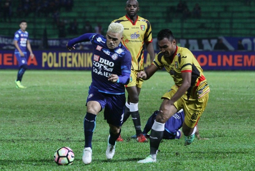 Pesepak bola Arema FC Cristian Gonzales (kiri) berusaha melewati hadangan pesepak bola Mitra Kukar Seftia Hadi (kanan) dalam pertandingan Liga 1 di Stadion Gajayana, Malang, Jawa Timur, Ahad (28/5).