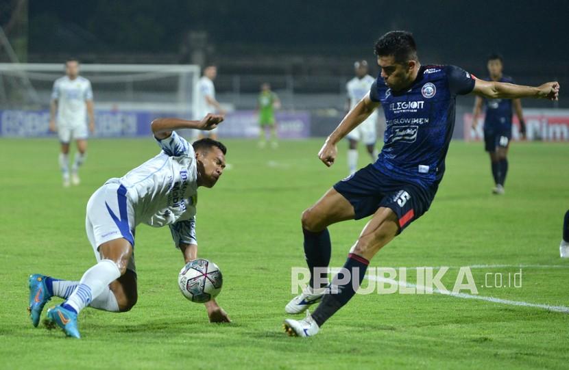 Pesepak bola Arema FC Fabiano Beltrame (kanan) berebut bola dengan pesepak bola Persib Bandung Erwin Ramdani (kiri) saat pertandingan Liga 1 di Stadion I Gusti Ngurah Rai, Denpasar, Bali, Rabu (9/3/2022). 