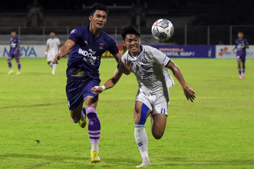 Pesepak bola Arema FC Feby Eka (kanan) berebut bola dengan pesepak bola Persita Syaeful Anwar (kiri) pada pertandingan Liga 1 di Stadion I Gusti Ngurah Rai, Denpasar, Bali, Selasa (15/2/2022) malam. Arema FC berhasil kalahkan Persita dengan skor 2-0. 