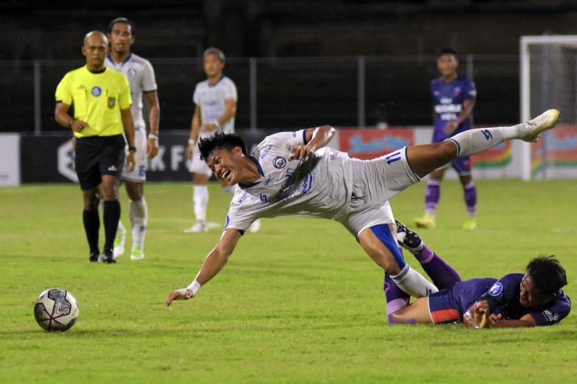 Pesepak bola Arema FC Feby Eka (tengah) berebut bola dengan pesepak bola Persita Ricki Ariansyah (kanan) pada pertandingan Liga 1 di Stadion I Gusti Ngurah Rai, Denpasar, Bali, Selasa (15/2/2022) malam. Arema FC berhasil kalahkan Persita dengan skor 2-0. 