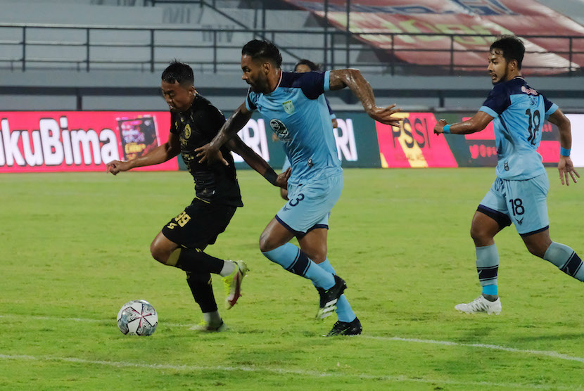 Pesepak bola Arema FC Kushedya Hari Yudo (kiri) berusaha melewati hadangan pesepak bola Persela Lamongan Demerson (tengah) pada pertandingan Liga 1 di Stadion Kapten I Wayan Dipta, Gianyar, Bali, Selasa (1/2/2022). 