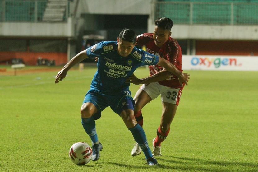 Pesepak bola Bali United Andhika W (kanan) berebut bola dengan pesepak bola Persib Bandung Vizcarra (kiri) saat pertandingan Piala Menpora di Stadion Maguwoharjo, Sleman, D.I Yogyakarta, Rabu (24/3/2021).