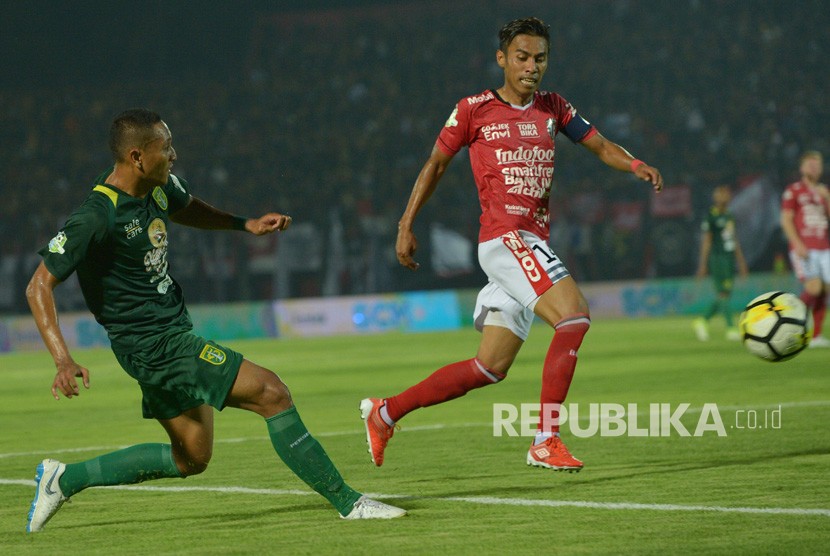 Pesepak bola Bali United, Fadil Sausu (kanan) menghadang pemain Persebaya Mokhamad Syaifuddin dalam pertandingan Sepak Bola Liga 1 di Stadion I Wayan Dipta, Gianyar, Bali, Minggu (18/11/2018). 