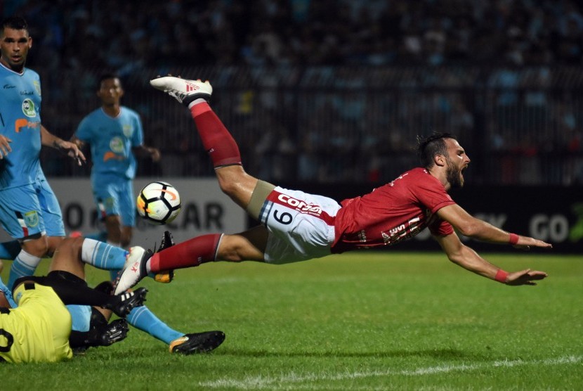 Pesepak bola Bali United Ilija Spasojevic terjatuh saat bertabrakan dengan pesepak bola Persela Lamongan dalam laga Liga 1 di Stadion Surajaya, Lamongan, Jawa Timur, Senin (16/4). Persela Lamongan ditahan imbang Bali United dengan skor 1-1. 